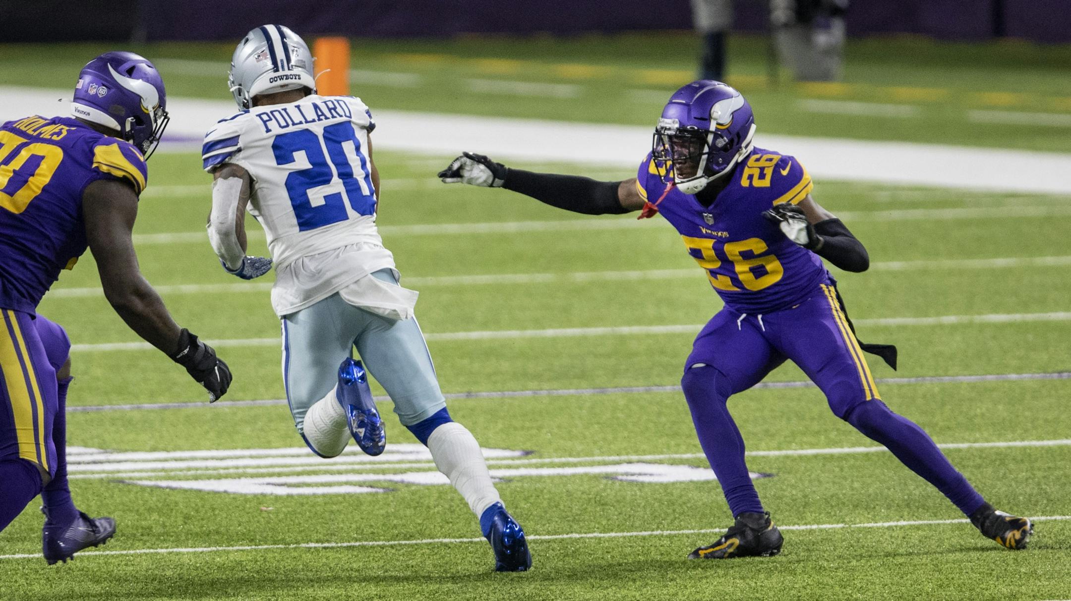 Dallas Cowboys running back Tony Pollard (20) ran past Minnesota Vikings' Jalyn Holmes (90) and Chris Jones (26) on his way to a touchdown in the fourth quarter.