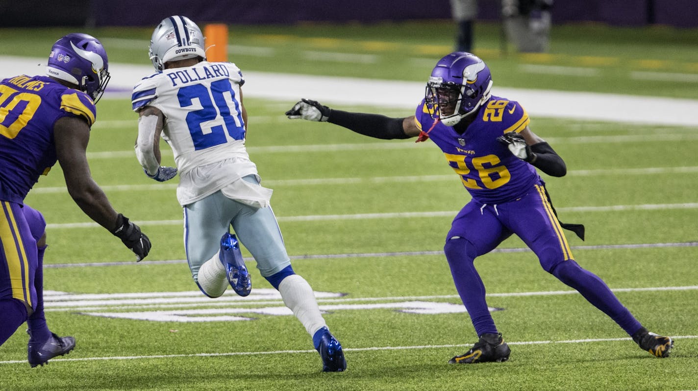 Dallas Cowboys running back Tony Pollard (20) ran past Minnesota Vikings' Jalyn Holmes (90) and Chris Jones (26) on his way to a touchdown in the fourth quarter.