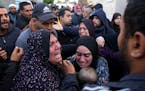 Palestinians mourn a baby killed in the Israeli bombardments of the Gaza Strip in front of the morgue of the Al Aqsa Hospital in Deir al Balah on Satu