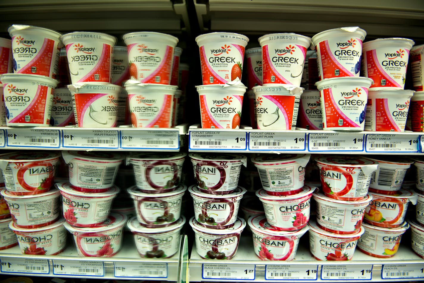 Yoplait USA Inc. brand greek yogurt sits on a shelf above Chobani Inc. greek yogurt at a supermarket in Princeton, Illinois, U.S., on Tuesday, June 4, 2013. The Food and Agriculture Organization of the United Nations will release its monthly food price index on June 6. The index, a measure of the monthly change in international prices of a basket of food commodities, consists of the average of five commodity group price indices including meat, dairy, grains, oil and sugar. Photographer: Daniel A