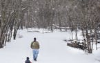 Jeff Booron of Minneapolis pulled his three-year-old son Hendrick Thaxton-Booronin a sled during a walk by a bridge that crosses to Pike Island at For