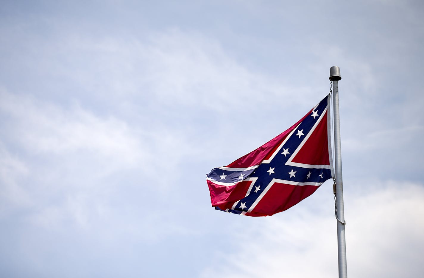 A Confederate flag flies at the base of Stone Mountain Tuesday, June 30, 2015, in Stone Mountain, Ga. At Georgia's iconic Stone Mountain, where the Confederacy is enshrined in a giant bas-relief sculpture, the Ku Klux Klan once held notorious cross-burnings and rebel battle flags still wave prominently, officials are considering what to do about those flags. The park, which now offers family-friendly fireworks and laser light shows, is readying its "Fantastic Fourth Celebration" Thursday through