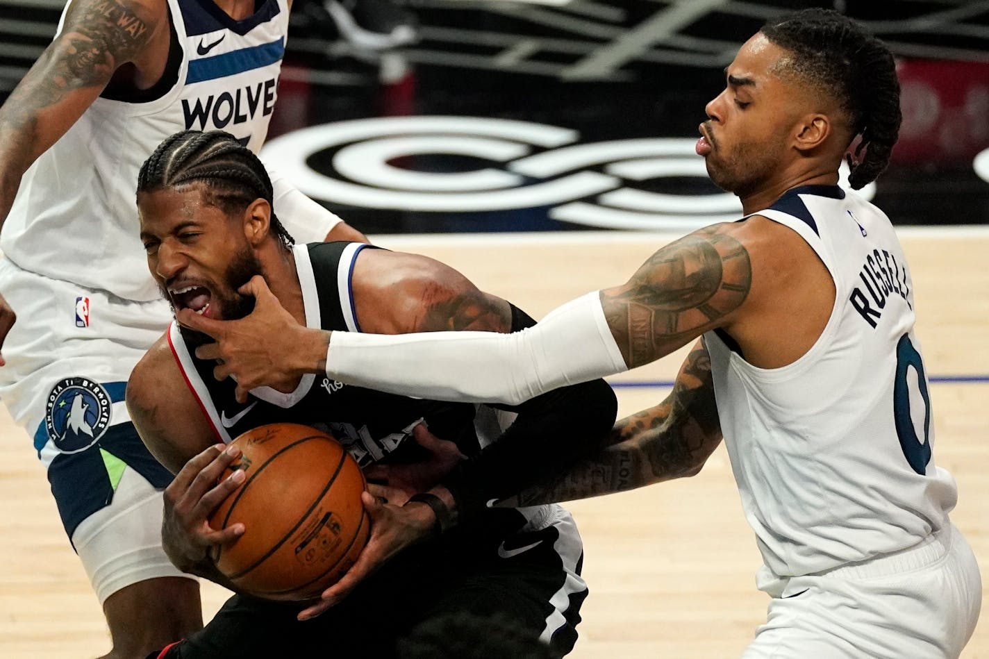 Minnesota Timberwolves guard D'Angelo Russell, right, hits Los Angeles Clippers guard Paul George in the mouth as George tries to shoot during the first half of an NBA basketball game Sunday, April 18, 2021, in Los Angeles. (AP Photo/Mark J. Terrill)