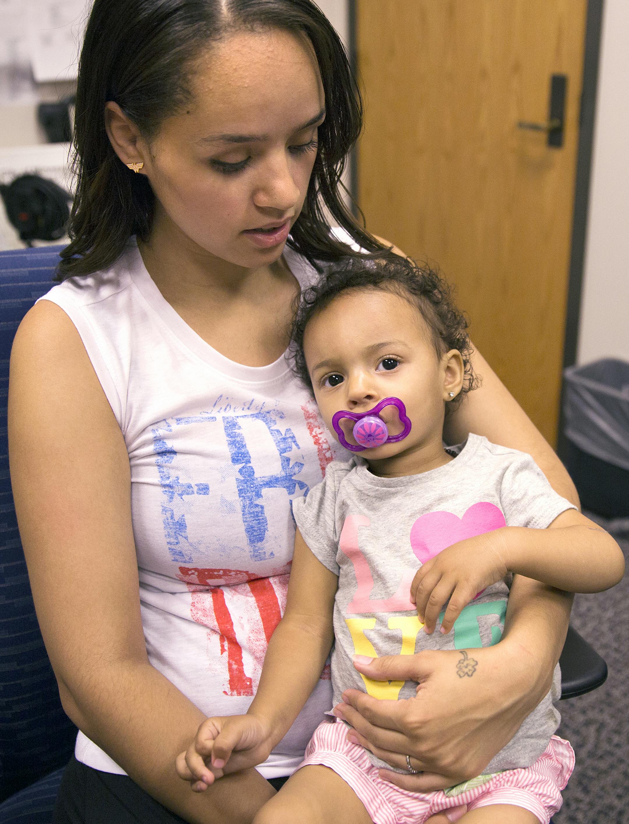 Shandrea Spielman, 22, talks to the media with her 16-month-old daughter Eden at the Minneapolis Police Department headquarters in Minneapolis on Friday, June 26, 2015. ] LEILA NAVIDI leila.navidi@startribune.com / BACKGROUND INFORMATION: Shandrea Spielman and her 15-month-old daughter Eden were both injured after being shot near Peavey Park in south Minneapolis last week. Donate Denae Peterson of Minneapolis was charged with multiple counts of attempted second-degree murder, second-degree assau