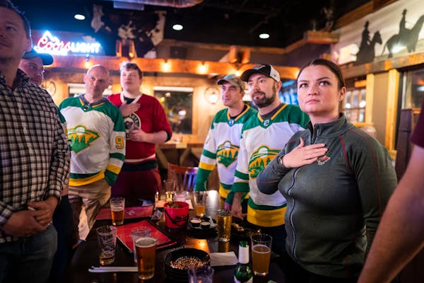 Yelena Kibasova, right, stood for the National Anthem with a group of Russian-American Wild fans gathered to watch the playoff game between the Wild a