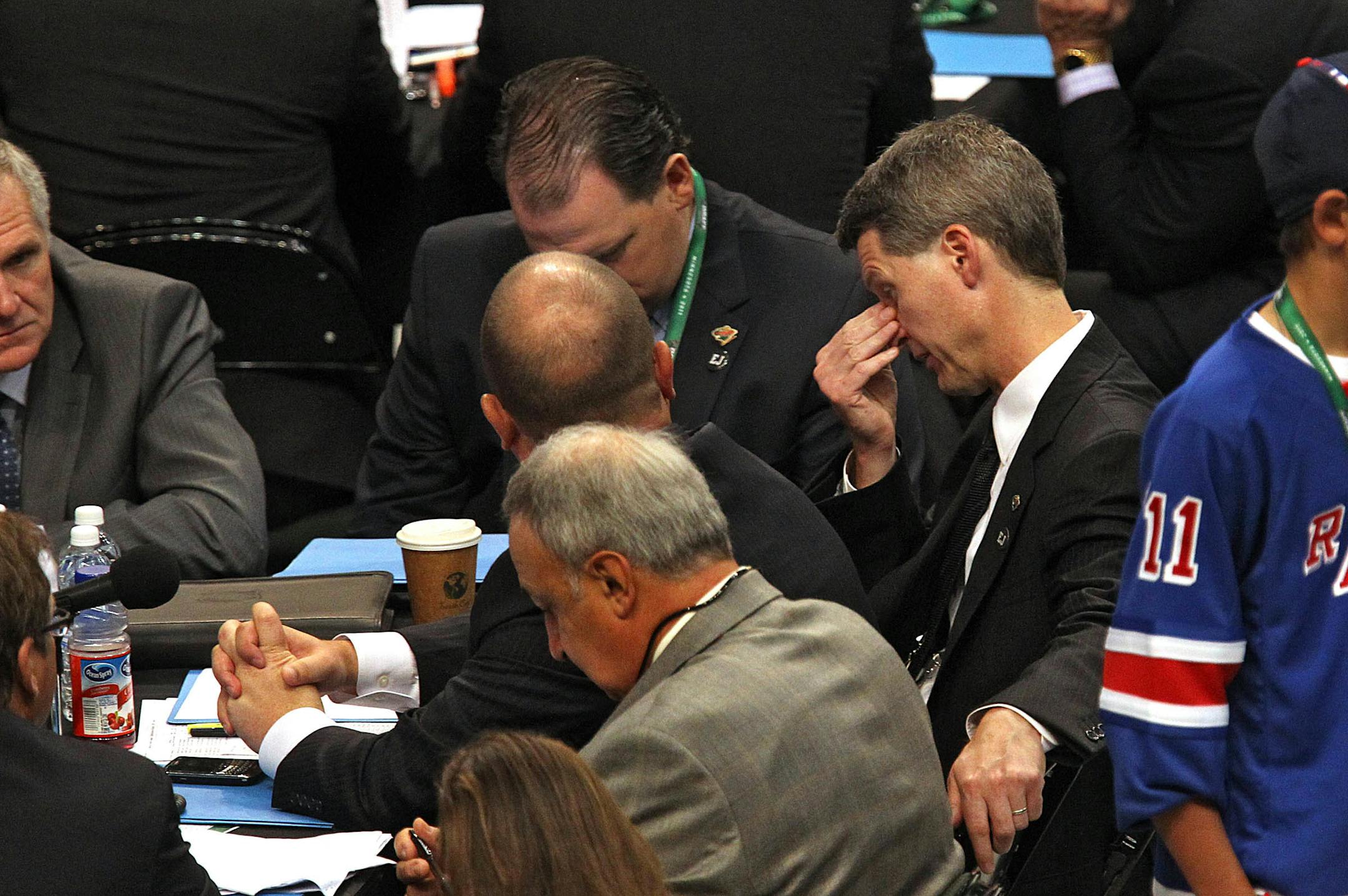 Wild General Manager Chuck Fletcher, right, consulted with other team officials during the 2011 NHL draft at Xcel Energy Center.