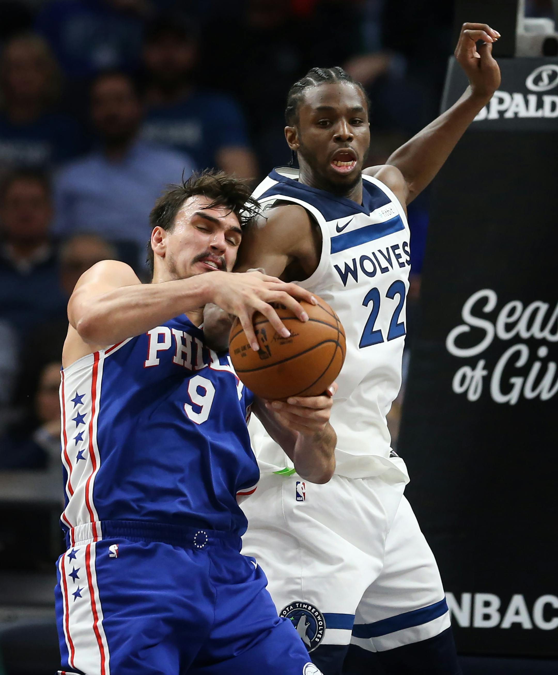 Minnesota Timberwolves forward Andrew Wiggins (22) and Philadelphia 76ers forward Dario Saric (9) battled for a loose ball during NBA action at Target Center Tuesday December 12, 2017 in Minneapolis, MN.] The Minnesota Timberwolves hosted the Philadelphia 76ers at Target Center. JERRY HOLT � jerry.holt@startribune.com