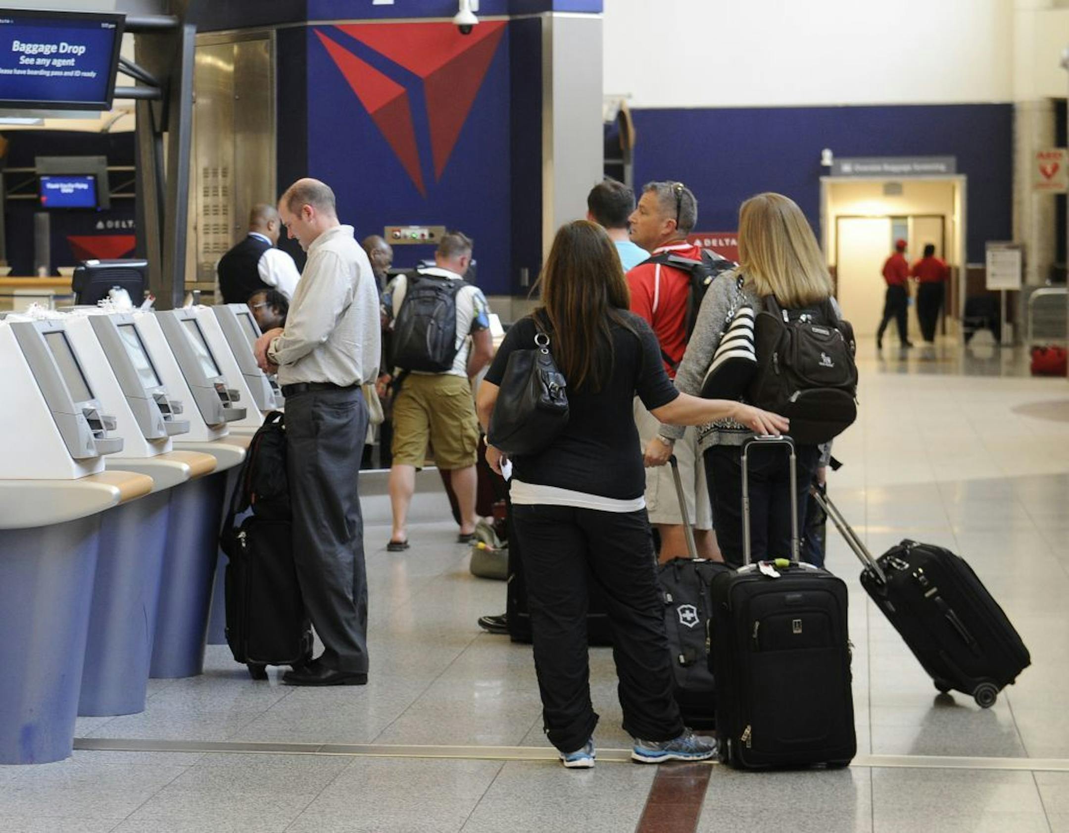 In this Friday, Sept. 27, 2013 photo, Delta Air Lines passengers line up to check luggage at Hartsfield-Jackson Atlanta International Airport, in Atlanta. Delta customers now have the option to purchase an upgrade that includes a free checked bag, among other perks.