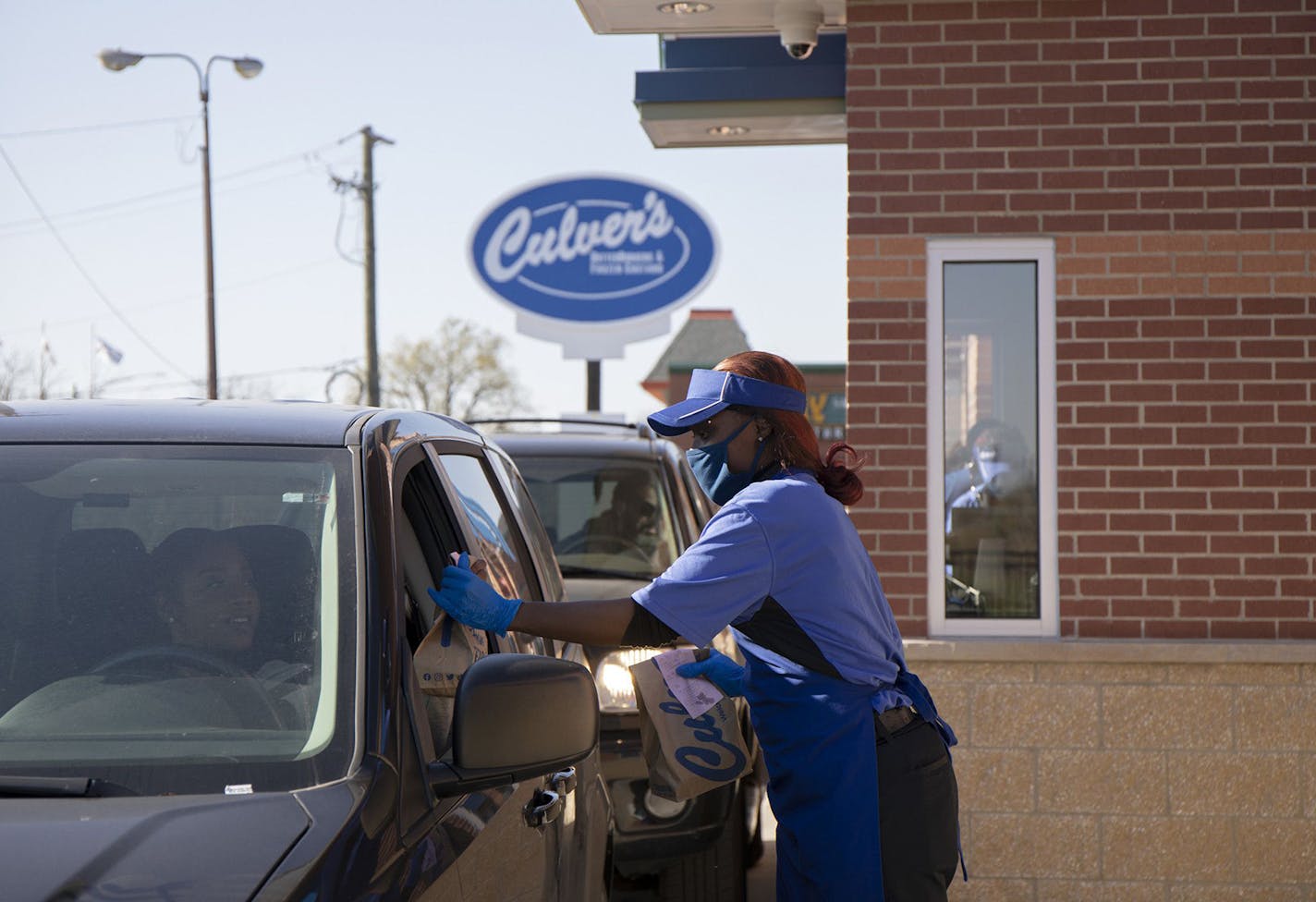 Culver's employee Teesha Nelson hands a drive-thru customer their order on Nov. 8, 2021, outside the restaurant chain's newest location in Pullman on its opening day. (Raquel Zaldivar/Chicago Tribune/TNS)