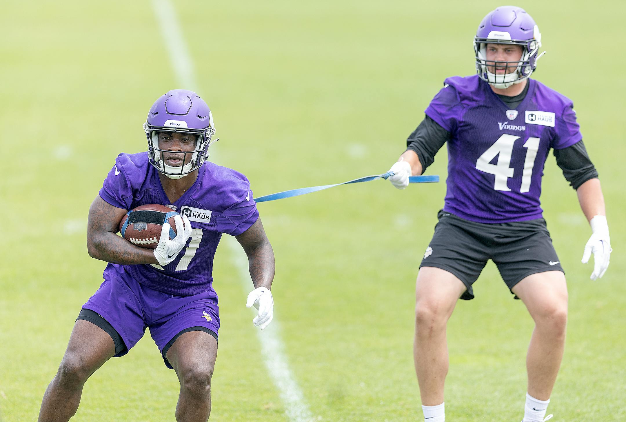 Vikings running back DeWayne McBride, left, and fullback Zach Ojile, right, run through drills during practice at the TCO Performance Center in Eagan, Minn., on Tuesday, June 6, 2023.