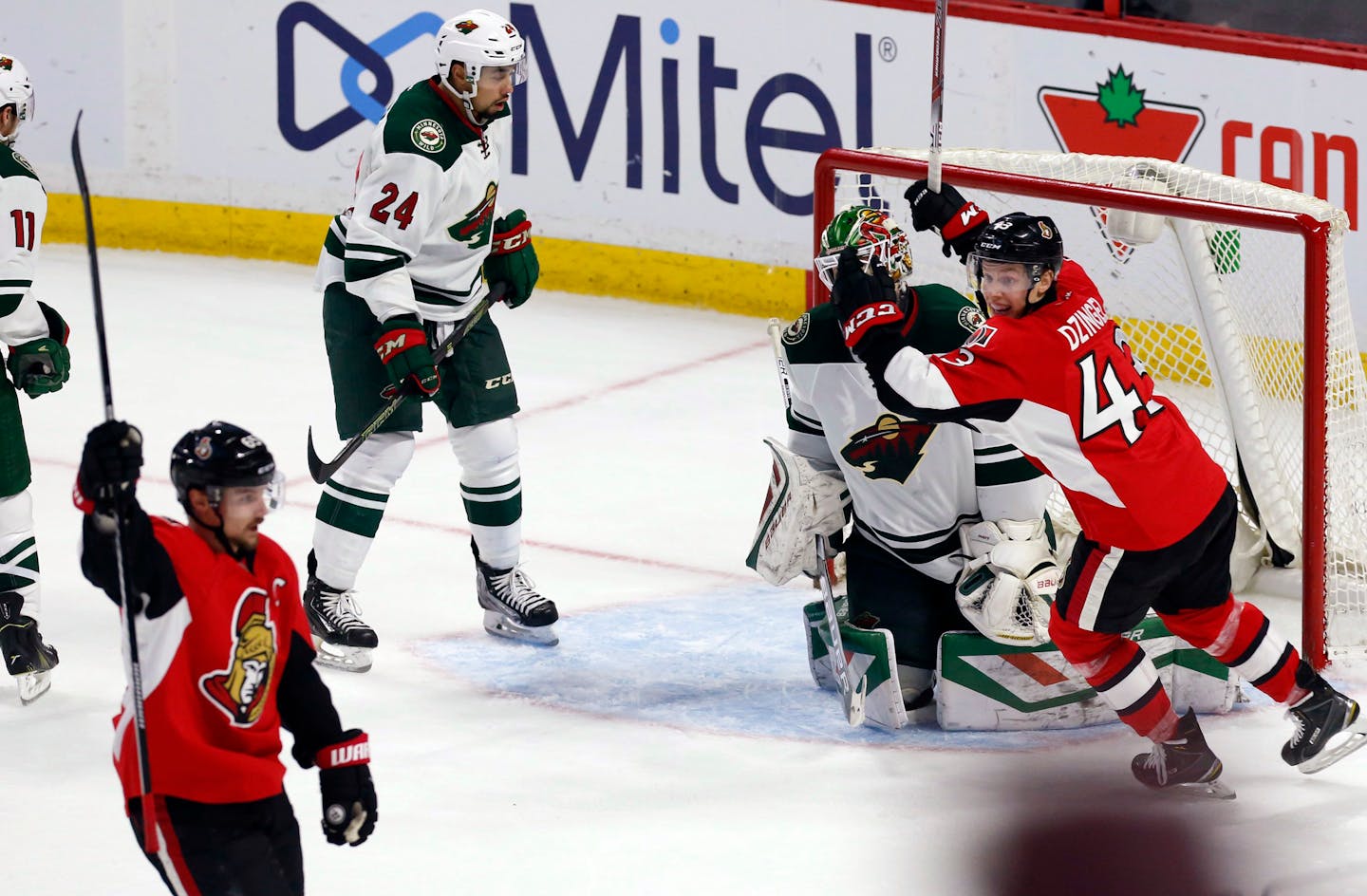 Minnesota Wild goaltender Devan Dubnyk (40) and teammate Matt Dumba (24) react as Ottawa Senators' Erik Karlsson, front left, celebrates his overtime goal with teammate Ryan Dzingel (43) in an NHL hockey game Tuesday, March 15, 2016, in Ottawa, Ontario. (Fred Chartrand/The Canadian Press via AP)