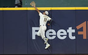 Brewers outfielder Jackson Chourio leaps to rob the Twins' Royce Lewis of a tying two-run homer in the eighth inning Sunday in Milwaukee.