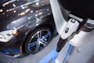An electric plug is hooked into a BMW vehicle during the Canadian International Auto Show in Toronto, Thursday, Feb. 16, 2017. (Mark Blinch/The Canadi