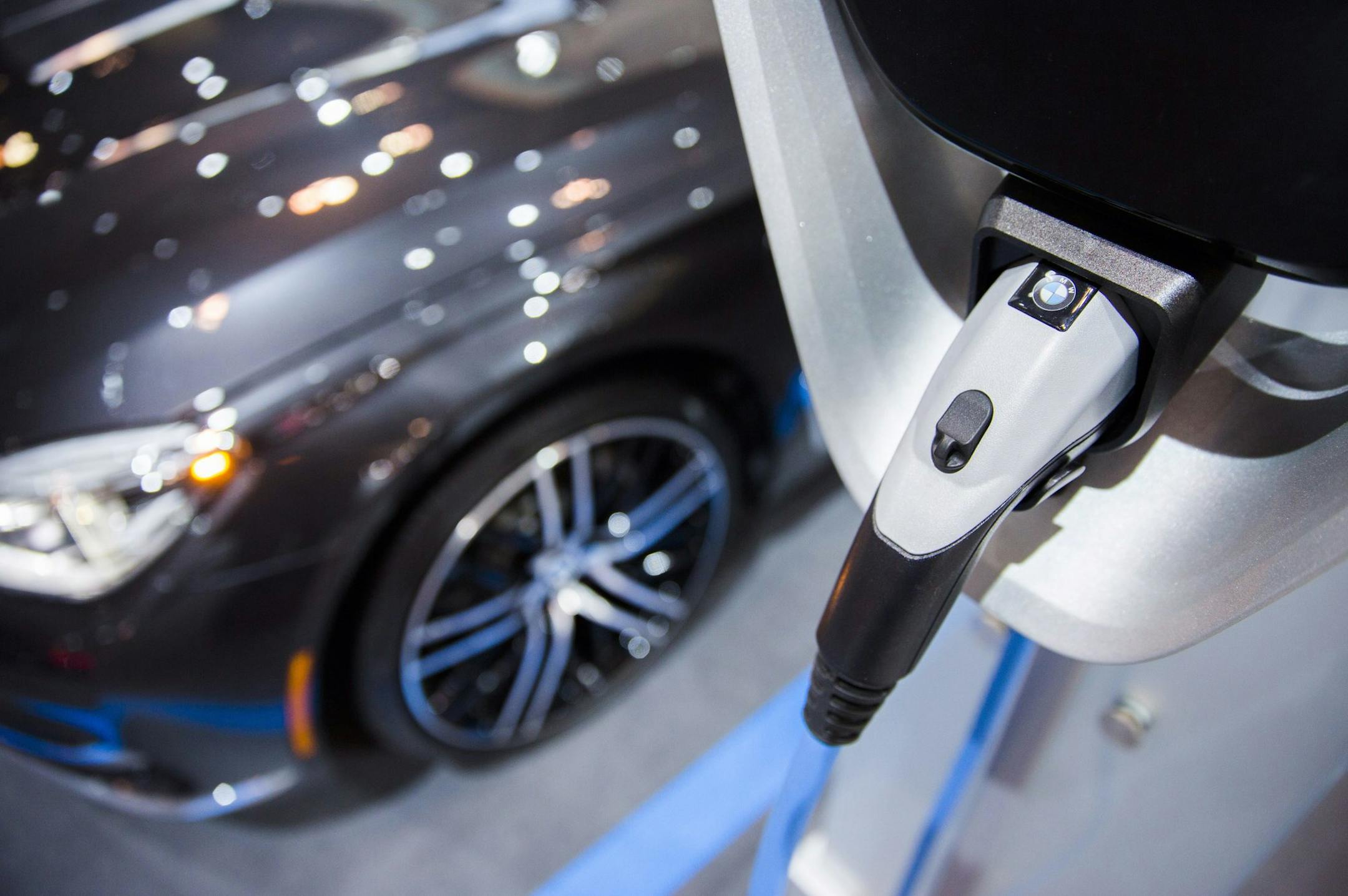 An electric plug is hooked into a BMW vehicle during the Canadian International Auto Show in Toronto, Thursday, Feb. 16, 2017. (Mark Blinch/The Canadian Press via AP)