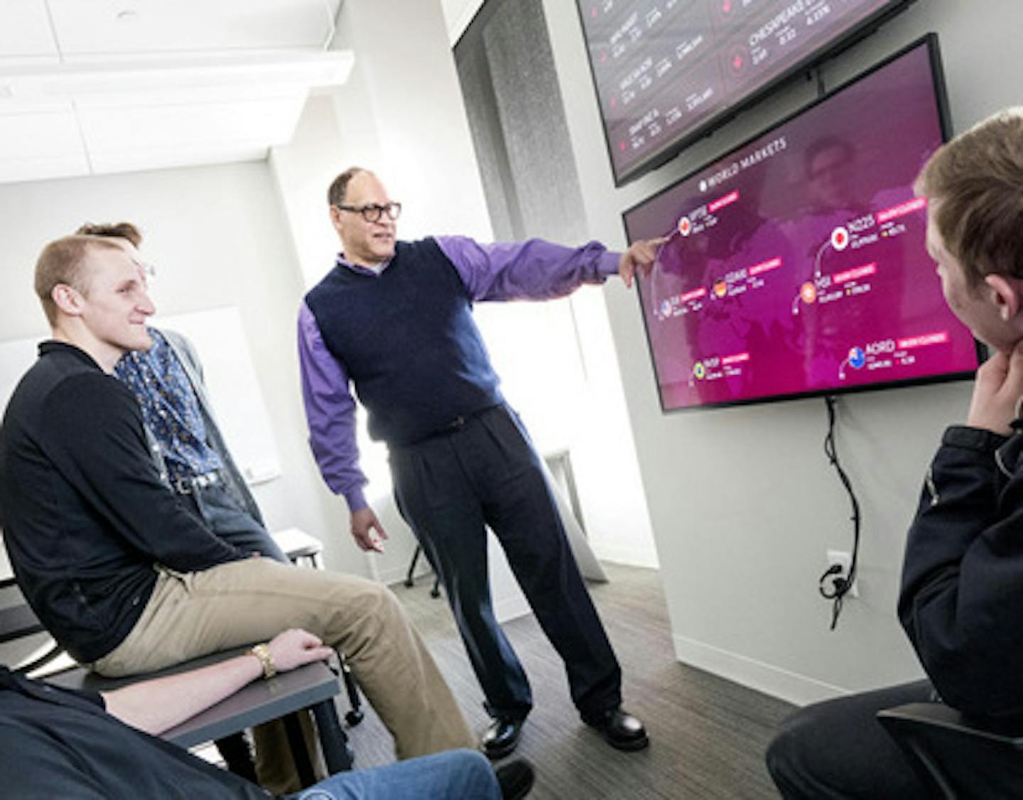 Marc McIntosh, a finance professor at Augsburg University, instructs students in the Hagfors Center for Science, Business and Religion. The business department, once scattered in several buildings around the Minneapolis campus, now has a financial-markets lab with real-time technology, a small business center and other building features that Augsburg management believes will help it better serve and attract students who might otherwise attend competing universities such as the neighboring Univer