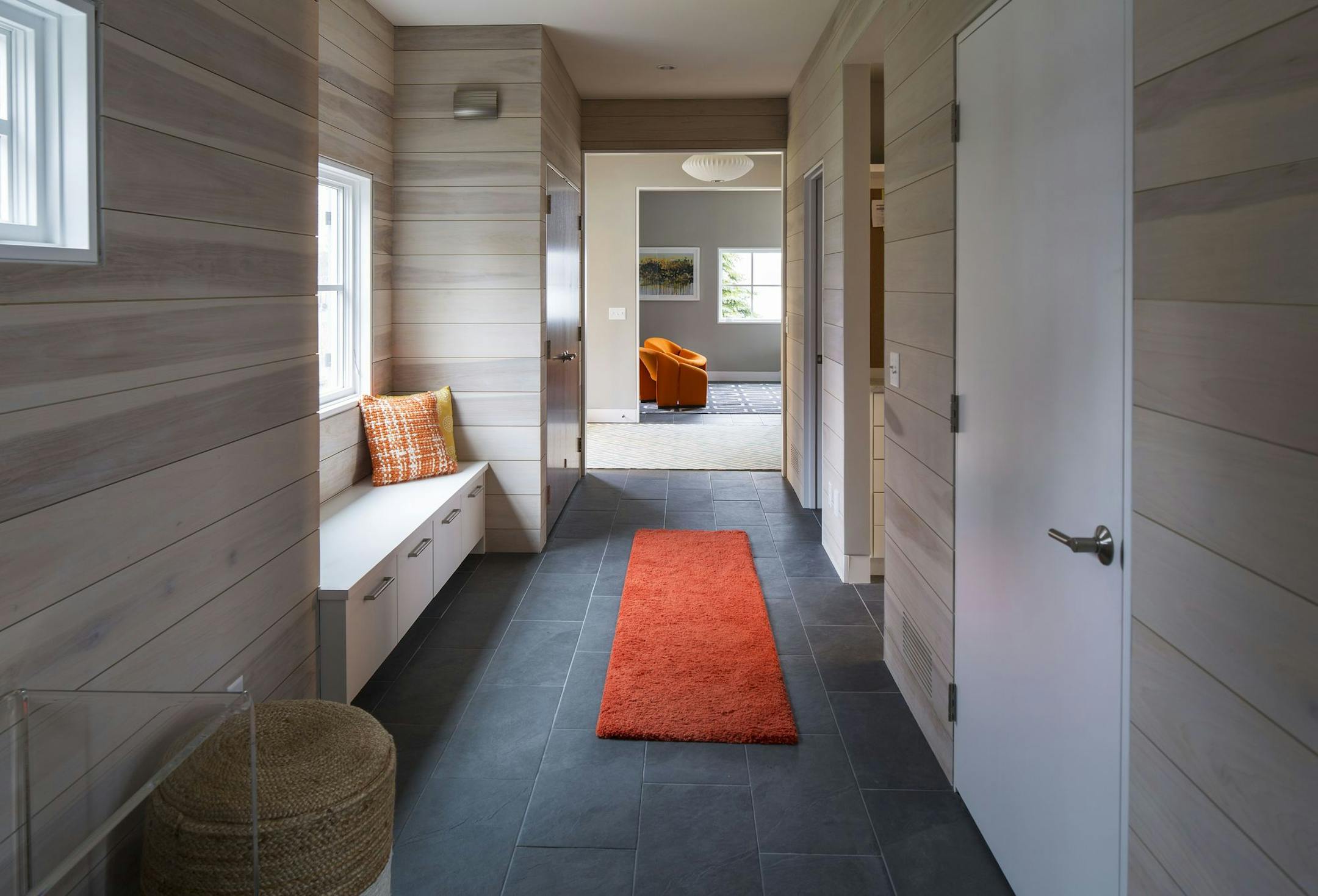 The mudroom/hallway walls are covered with "beachy" whitewashed shiplap.