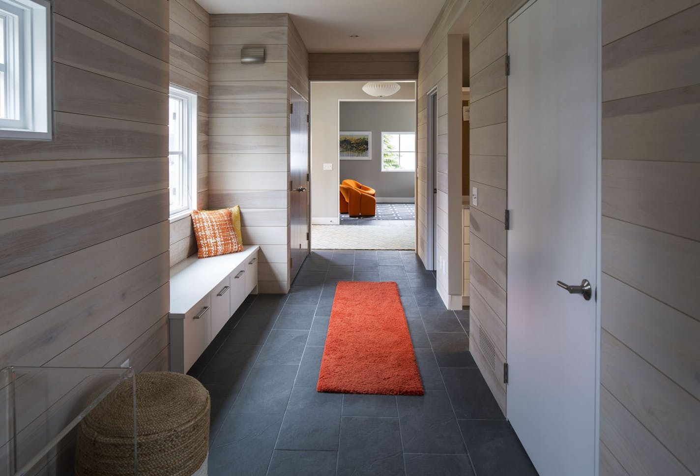 The mudroom/hallway walls are covered with "beachy" whitewashed shiplap.