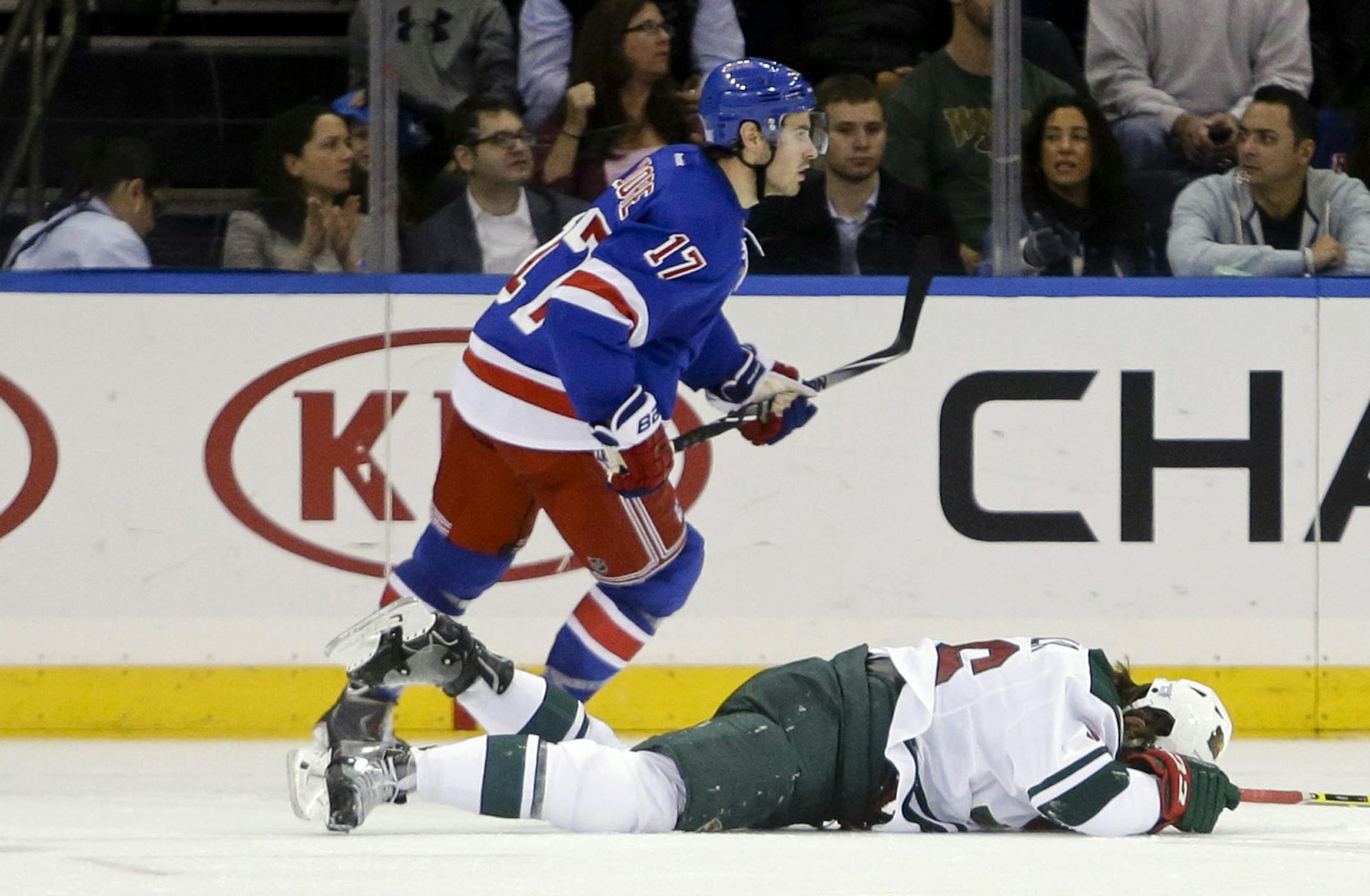 Minnesota Wild's Erik Haula, bottom, holds his head after being hit by New York Rangers' John Moore (17) during the second period of an NHL hockey game Monday, Oct. 27, 2014, in New York. Moore was given a match penalty for the hit.
