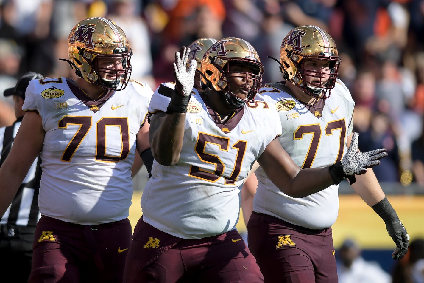 Minnesota Gophers offensive lineman Curtis Dunlap Jr. (51) celebrated alongside offensive lineman Sam Schlueter (70) and offensive lineman Blaise Andries (77) after a touchdown against the Auburn Tigers in the second quarter.