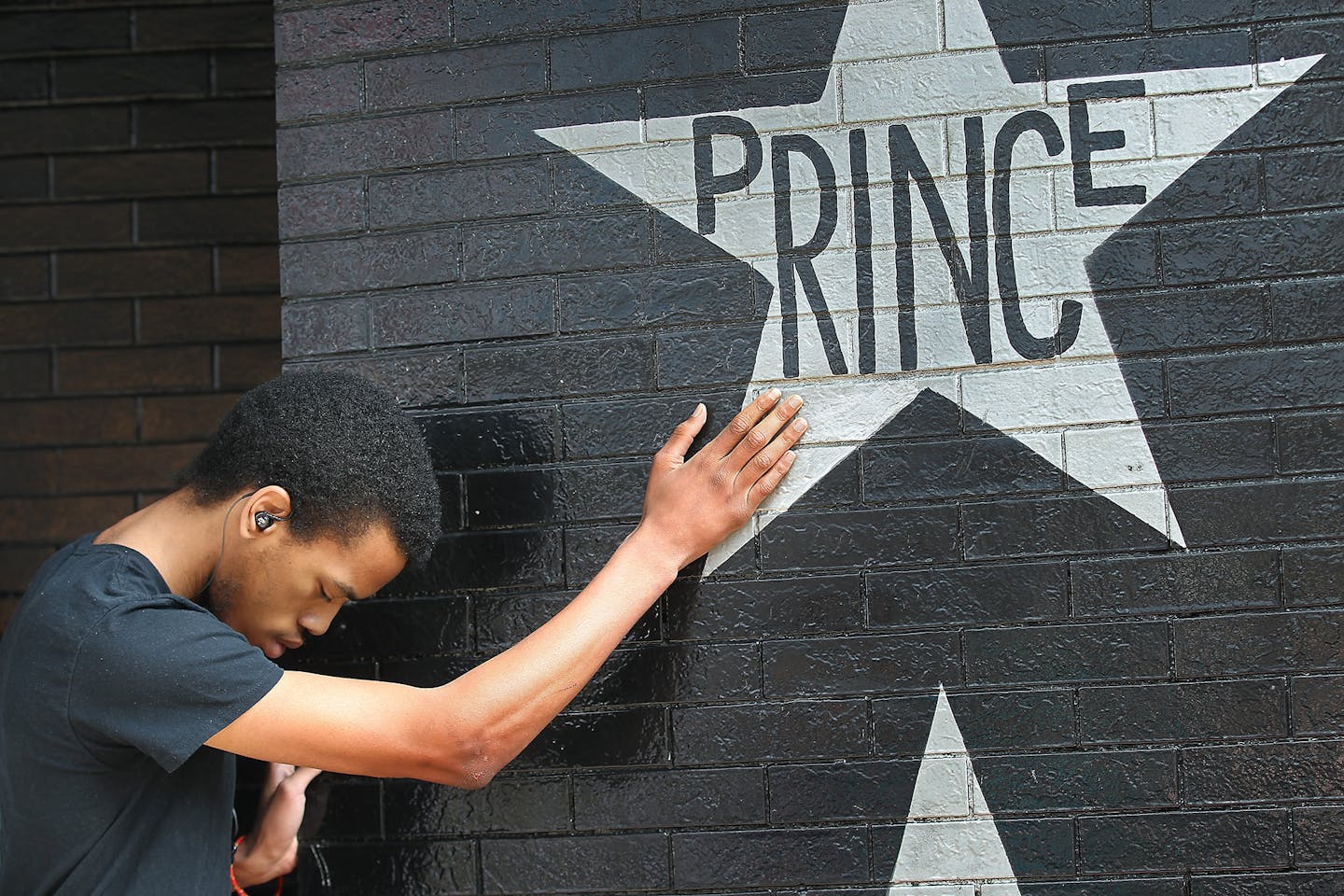 Antonio Carnell, 20, took a moment to touch Prince's star as many gathered at First Avenue after news of his death was made, Thursday, April 21, 2016 in Minneapolis, MN.