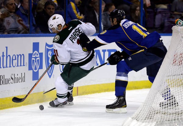 The Wild's Zach Parise, left, and St. Louis' Jay Bouwmeester chased a loose puck during the first period Monday night.