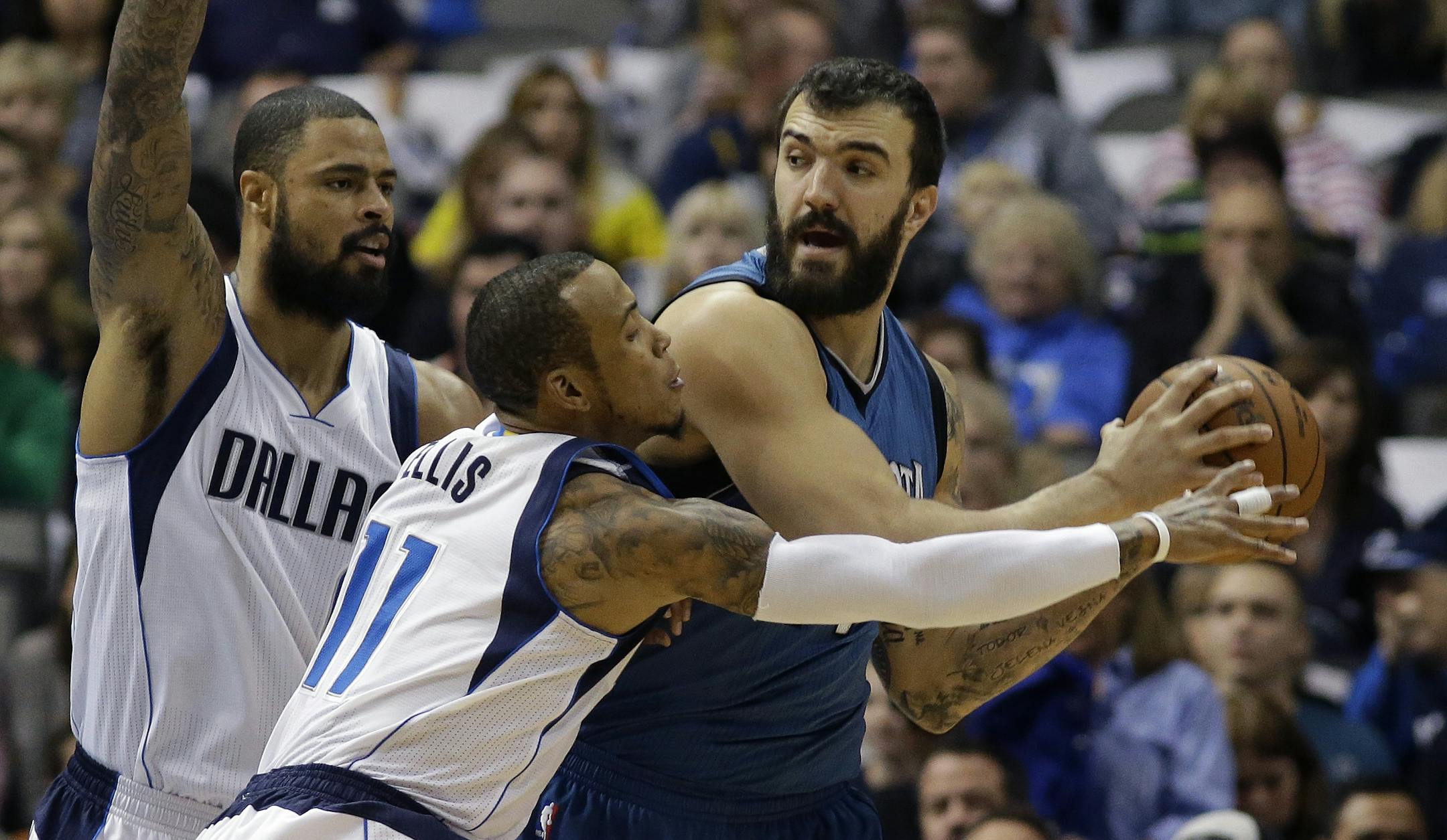 Minnesota Timberwolves center Nikola Pekovic (14) keeps the ball from Dallas Mavericks guard Monta Ellis (11) and center Tyson Chandler (6) during the first half of an NBA basketball game, Saturday, Nov. 15, 2014, in Dallas. (AP Photo/LM Otero)
