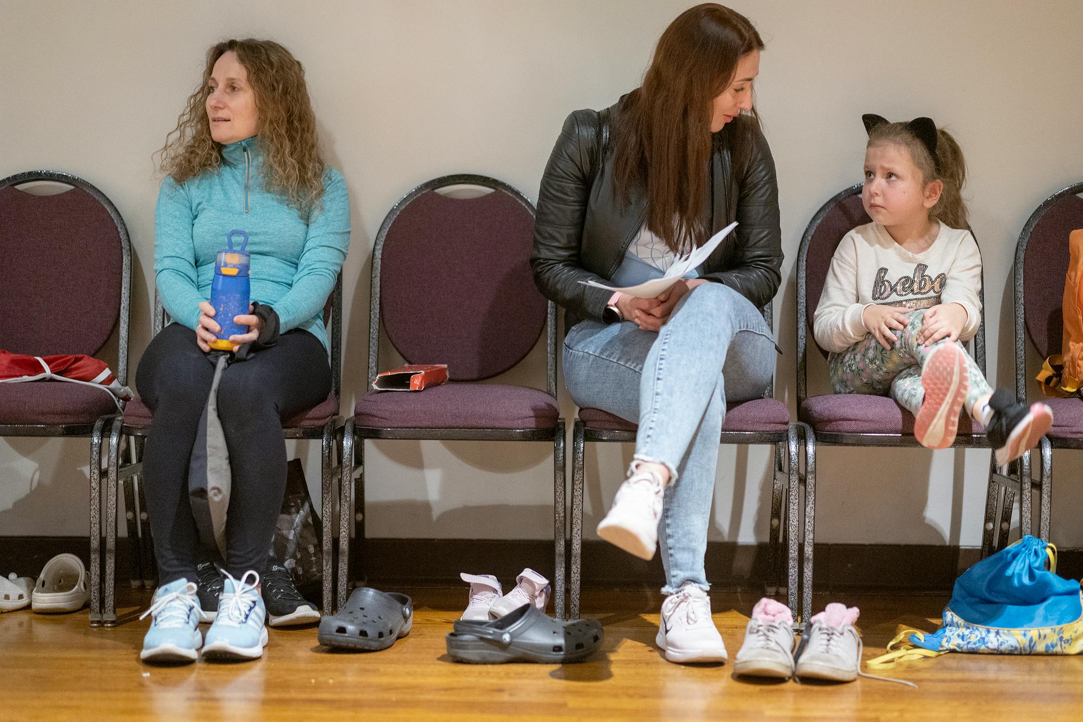 Ukrainian refugee Natalia Kuchma, center, attempts to coax her daughter Solomiia Kuchma, 5, to join other dancers during a dance class at the Ukrainian American Community Center in Minneapolis. Solomiia has a difficult time leaving her mother's side.