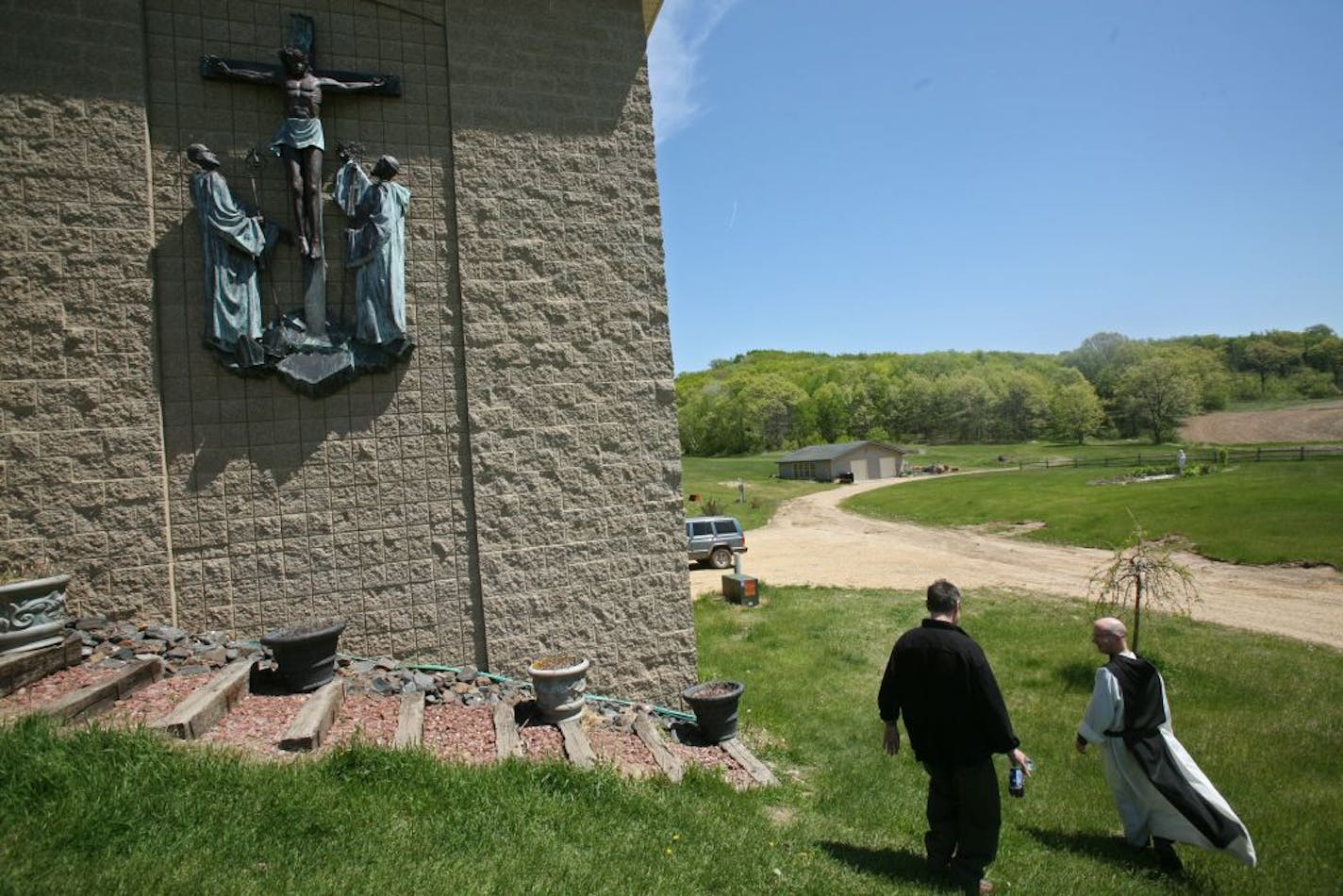 Father Bernard McCoy, right, walks with another man outside the new abbey, May 19, 2009 at the Cistercian Abbey Our Lady of Spring Bank in Sparta, Wisconsin. The abbey and the 40 acres that it sits on are now listed for sale at $2.6 million.