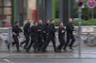 In this grab taken from video, police run in the area of the Olympia Einkaufszentrum mall, after a shooting, in Munich, Germany, Friday, July 22, 2016