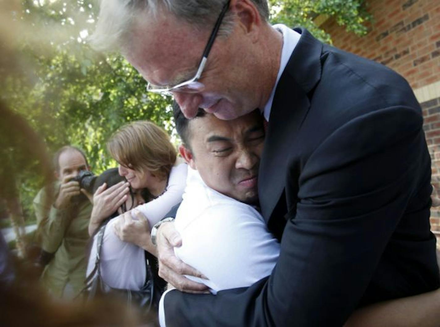 Fong is hugged by Hilliard, right, and Moua is hugged by Erika Applebaum of the Innocence Project of Minnesota after he was released from jail.