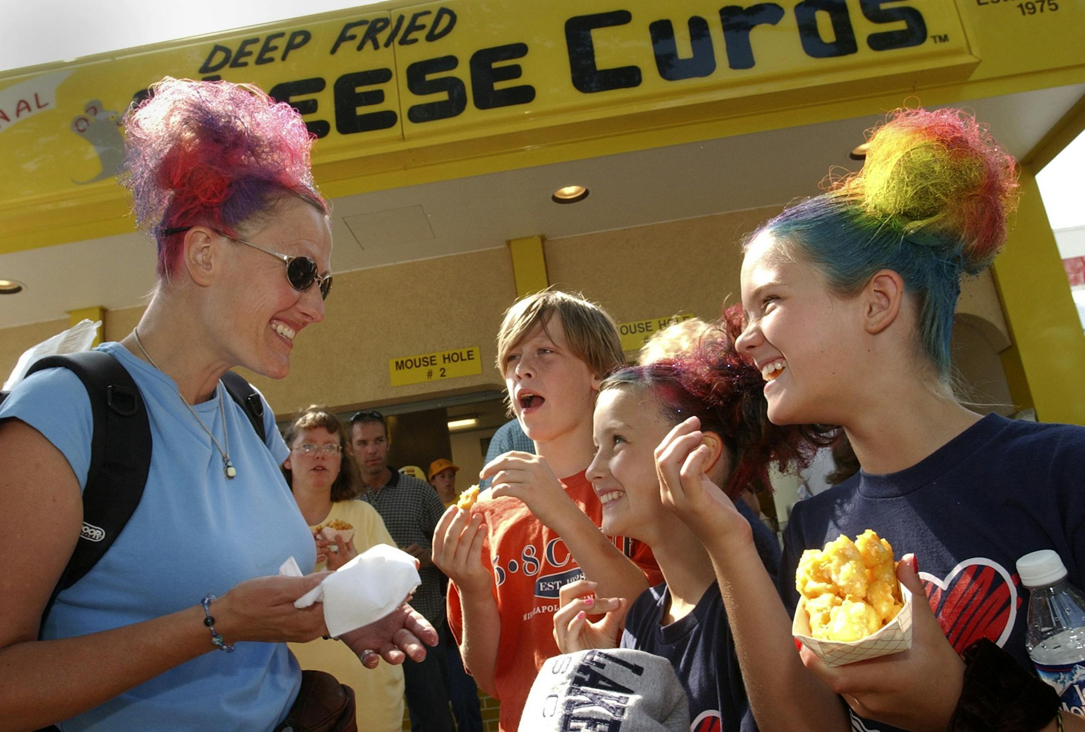 Joey McLeister/Star Tribune Falcon Heights,Thurs.,Aug. 25, 2005--Enjoying Cheese Curds at The Original Cheese Curd booth are (left to right) Shelley Johnson, 11-year-old Sam Johnson, nine-year-old Maddy Johnson and 10-year-old Ellie Nistler. The women had their hair done at the fair. The Original Cheese Curds booth has been there since 1975.
GENERAL INFORMATION: Smells at the Minnesota State Fair.
