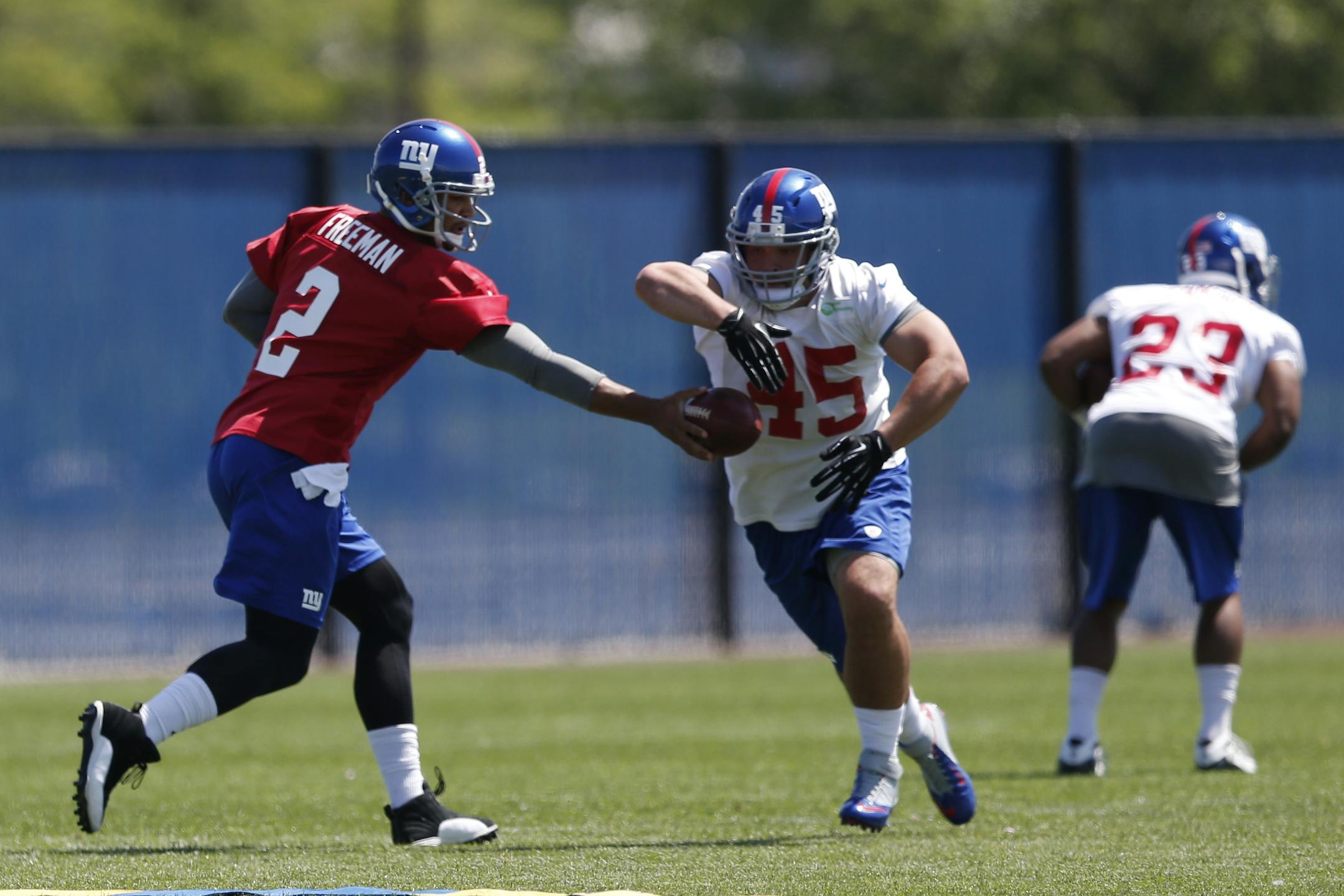 New York Giants quarterback Josh Freeman, left, hands off to full back Henry Hynoski during an NFL football organized team activity, Thursday, May 29, 2014, in East Rutherford, N.J. (AP Photo/Julio Cortez)