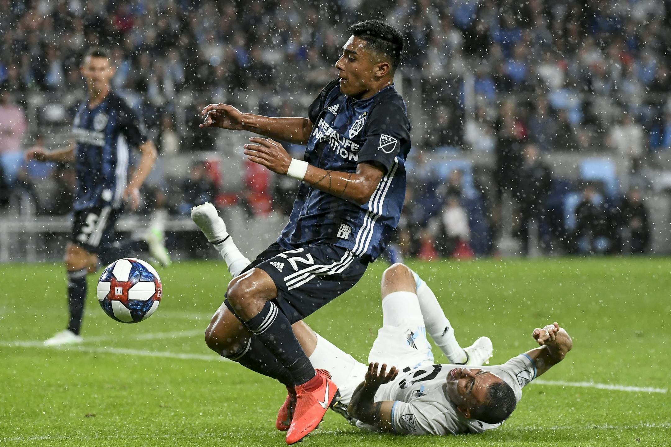 Minnesota United midfielder Miguel Ibarra (10) fell to the pitch as he was challenged by Los Angeles Galaxy defender Julian Araujo (22) in the second half.