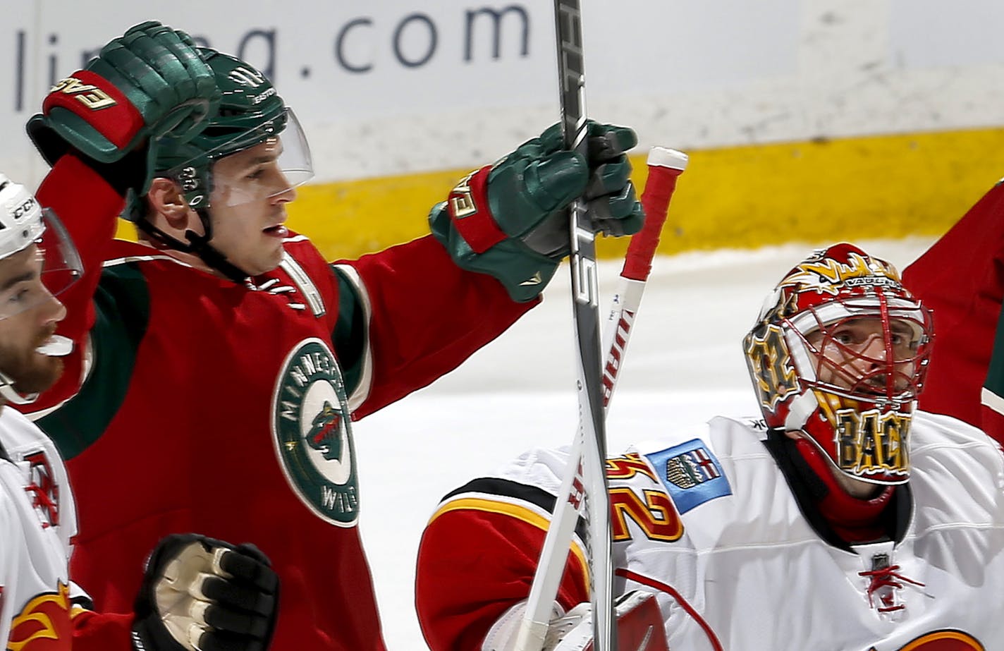 After shooting the puck past Calgary Flames goalie Niklas Backstrom, Zach Parise (11) celebrated after scoring his third goal in the first period.