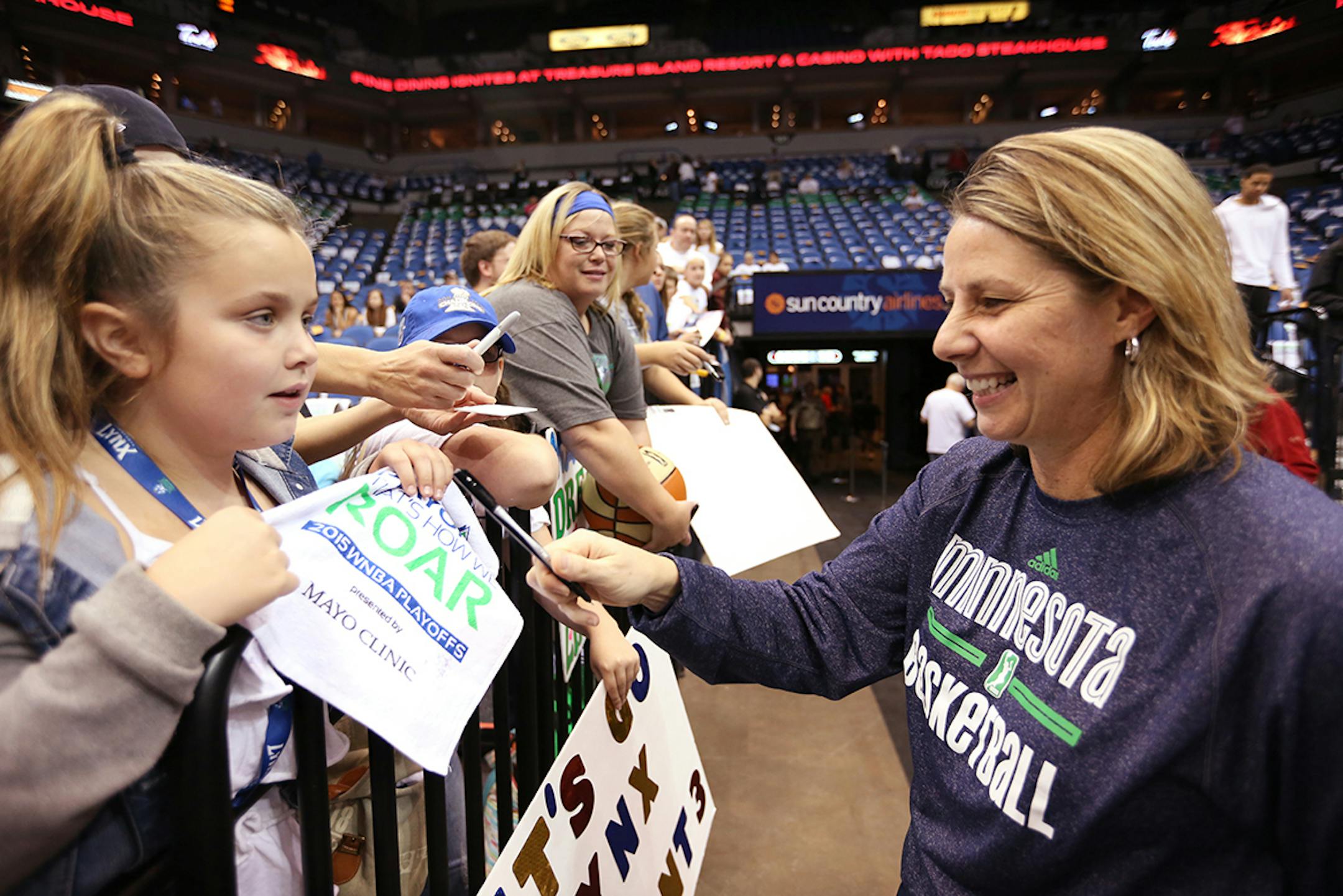 Minnesota Lynx coach Cheryl Reeve signs an autograph for Isabella Miller, 8, of St. Louis Park before the game.
