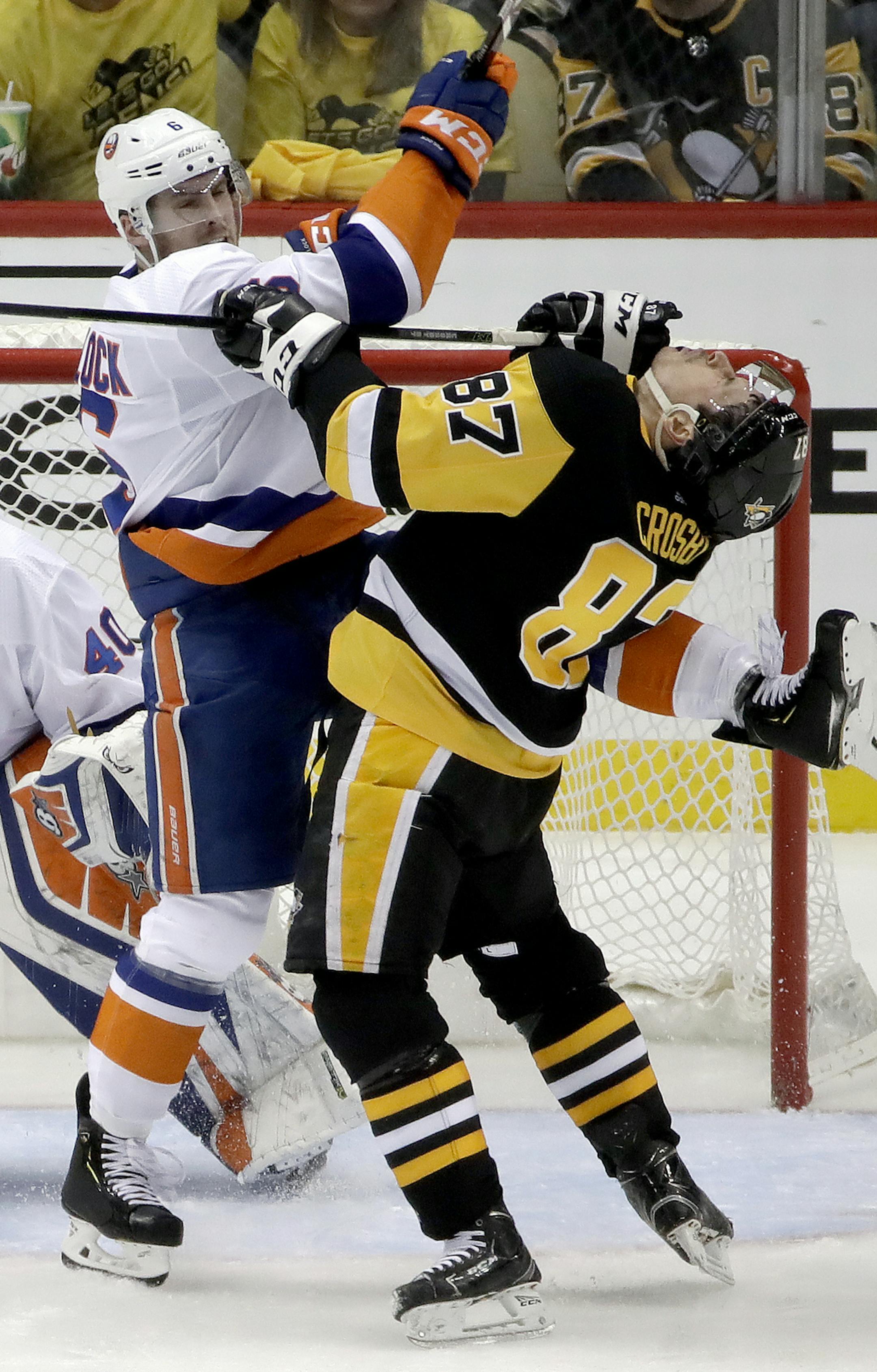 New York Islanders' Ryan Pulock (6) and Pittsburgh Penguins' Sidney Crosby (87) battle for position in front of goaltender Robin Lehner during the third period in Game 4 of an NHL first-round hockey playoff series in Pittsburgh, Tuesday, April 16, 2019. The Islanders won 3-1, sweeping the series. (AP Photo/Gene J. Puskar)