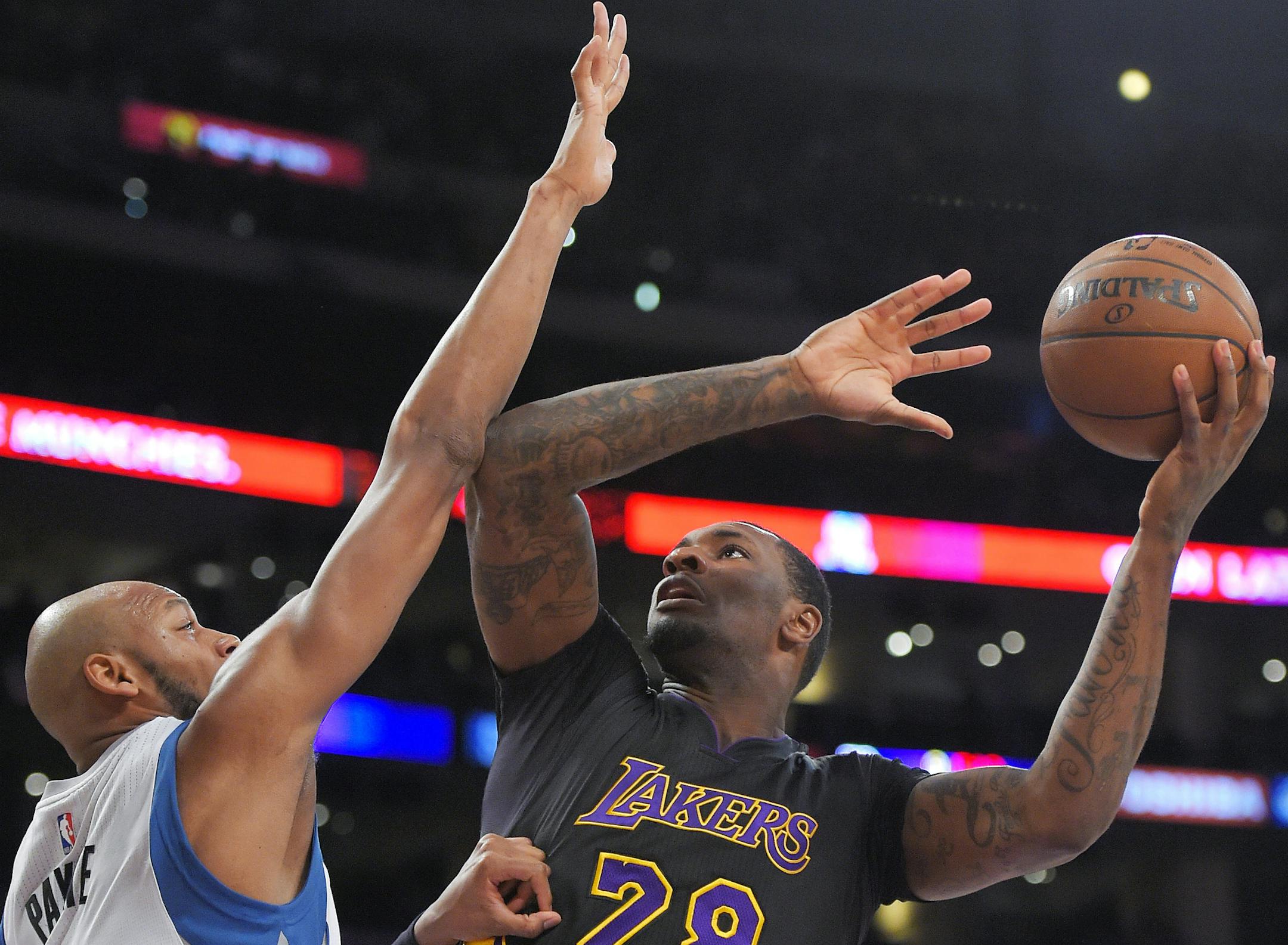 Los Angeles Lakers forward Tarik Black, right, shoots as Minnesota Timberwolves forward Adreian Payne defends during the first half of an NBA basketball game, Friday, April 10, 2015, in Los Angeles. (AP Photo/Mark J. Terrill)