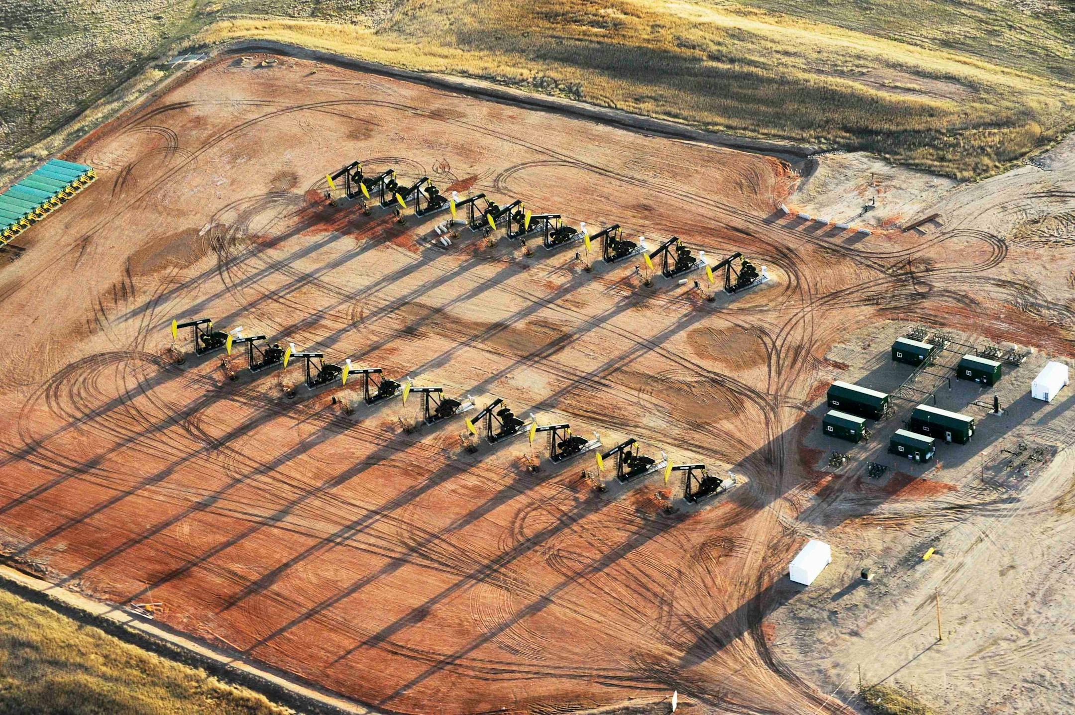 FILE PHOTO - Eighteen oil pumpjacks are seen on a Hess well pad near Tioga, North Dakota April 30, 2016. REUTERS/Andrew Cullen/File Photo