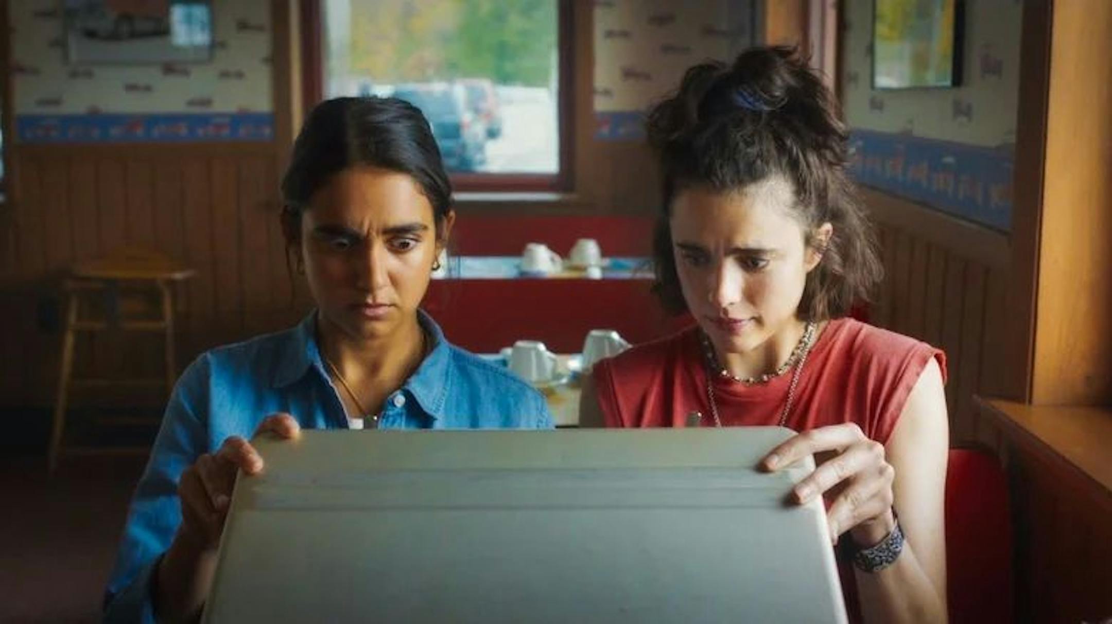 image of two women in a diner, opening a briefcase
