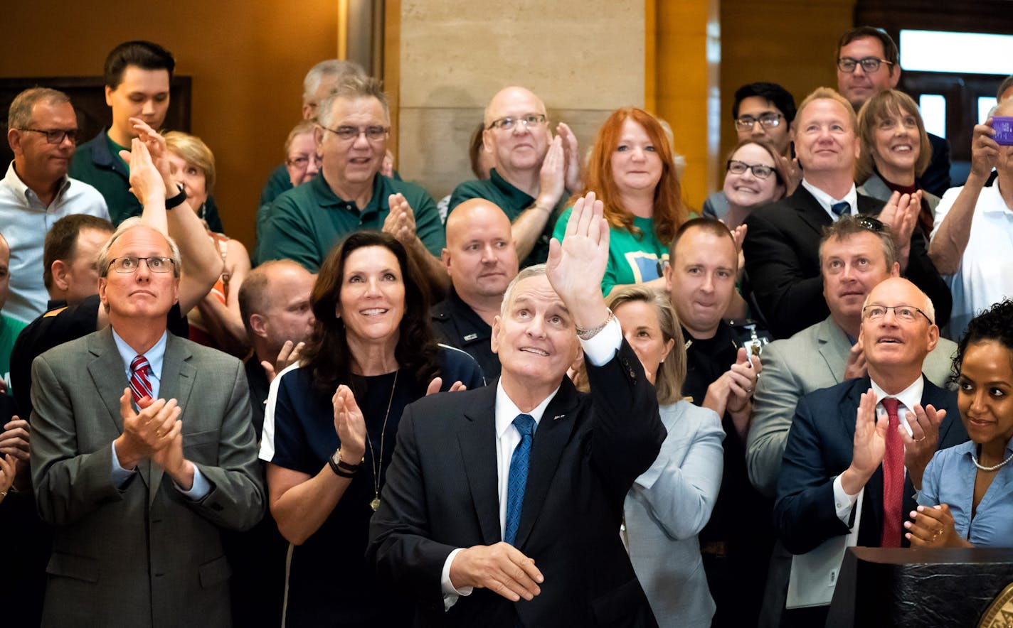 Governor Dayton waved to the crowd gathered on the second and third floors of the Rotunda just before signing the bill. Surrounded by commissioners, legislators, workers, and retirees in the Capitol Rotunda, Gov. Mark Dayton signed the pension bill into law Thursday. The legislation reduces the state's pension fund liabilities and alleviates public workers' and retirees' fears that the retirement fund could eventually run short, which would hurt hundreds of thousands of Minnesotans. ] GLEN STUBB