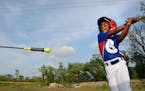 Anija Sheffield, 8, practiced her swing during warm-ups last month at the Little League complex in Brooklyn Center. In the background was debris that 