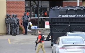 Officers stand near an entrance to the Wells Fargo branch Thursday May 6, 2021, in south St. Cloud, Minn. following a reported hostage situation. Poli