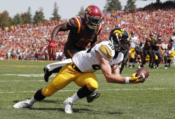 Iowa wide receiver Matt VandeBerg catches a 17-yard touchdown pass in front of Iowa State defensive back Brian Peavy, left, during the first half of a