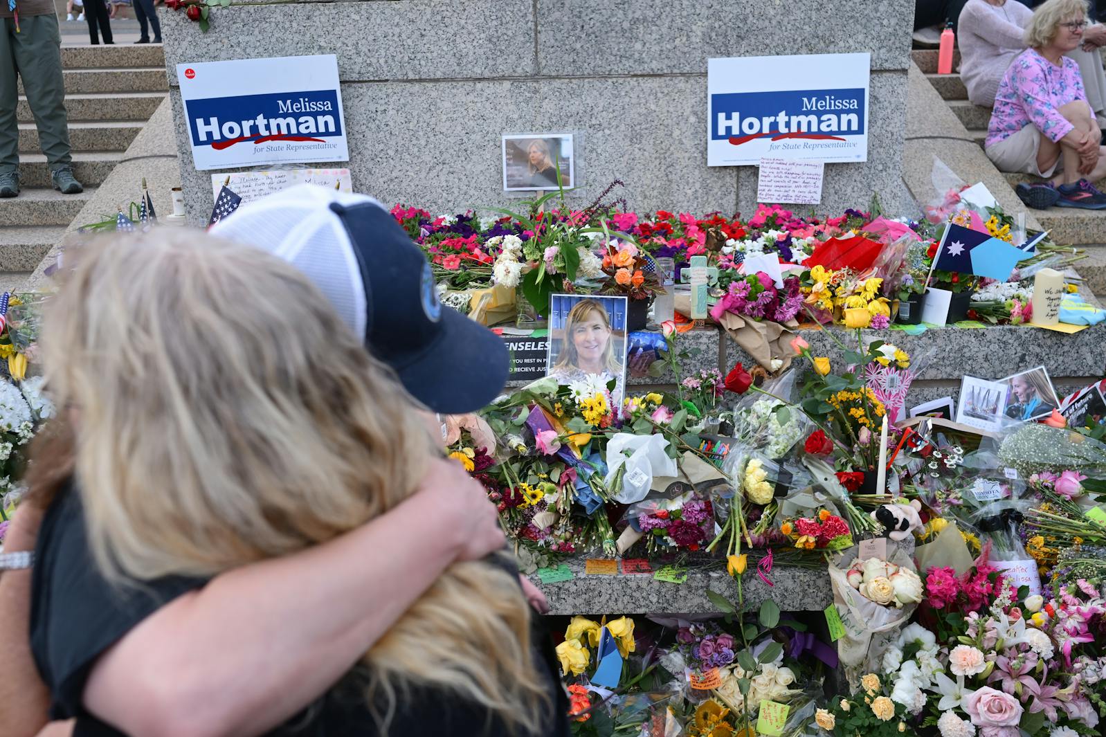 Mourners hug at the start of the candlelight vigil for Melissa and Mark Hortman at the State Capitol building on Wednesday.