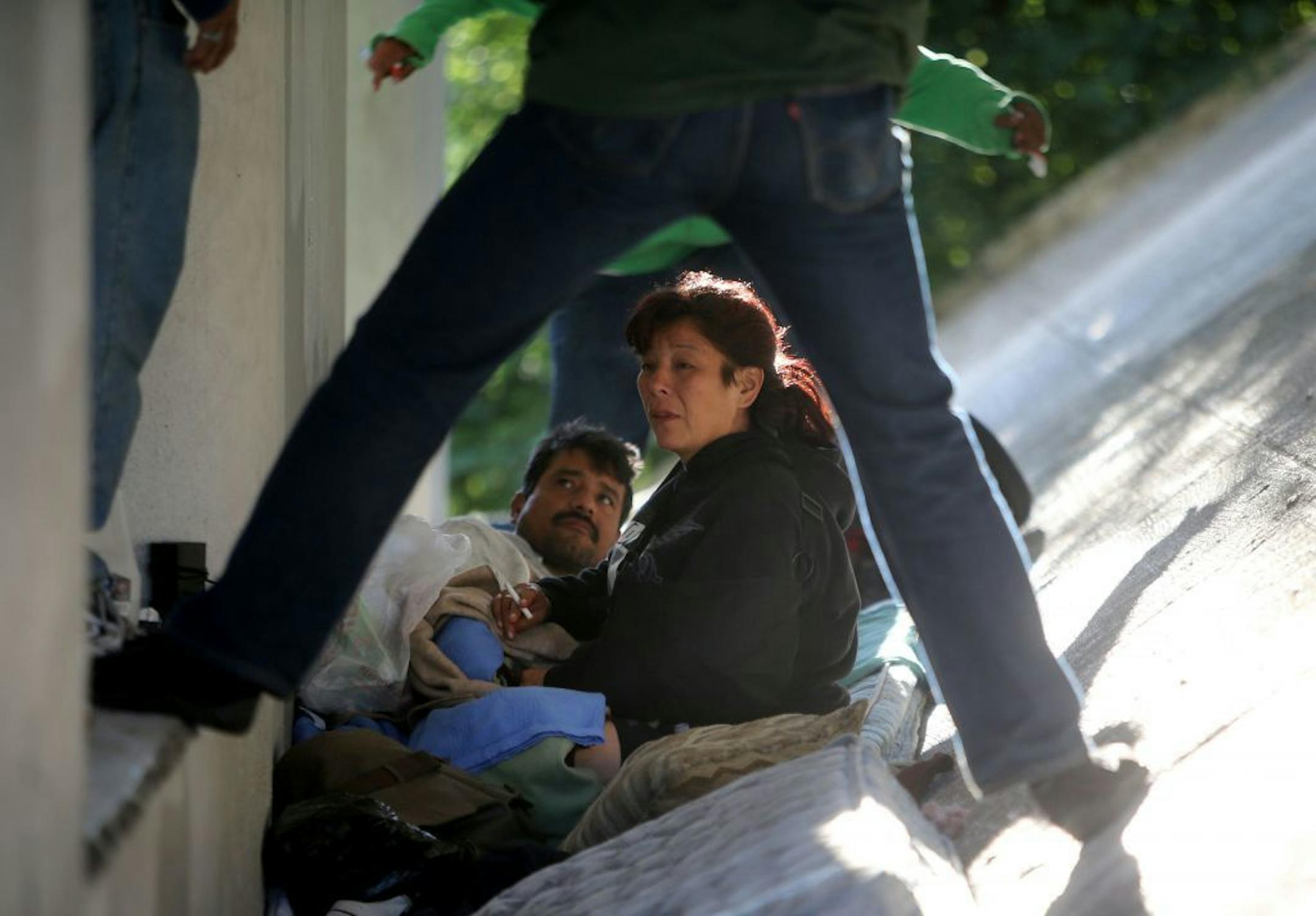 Homeless people talk on a steep incline where they sleep, beneath the Blaisdell Avenue bridge Thursday, Aug. 20, 2015, along the Midtown Greenway in Minneapolis, MN.