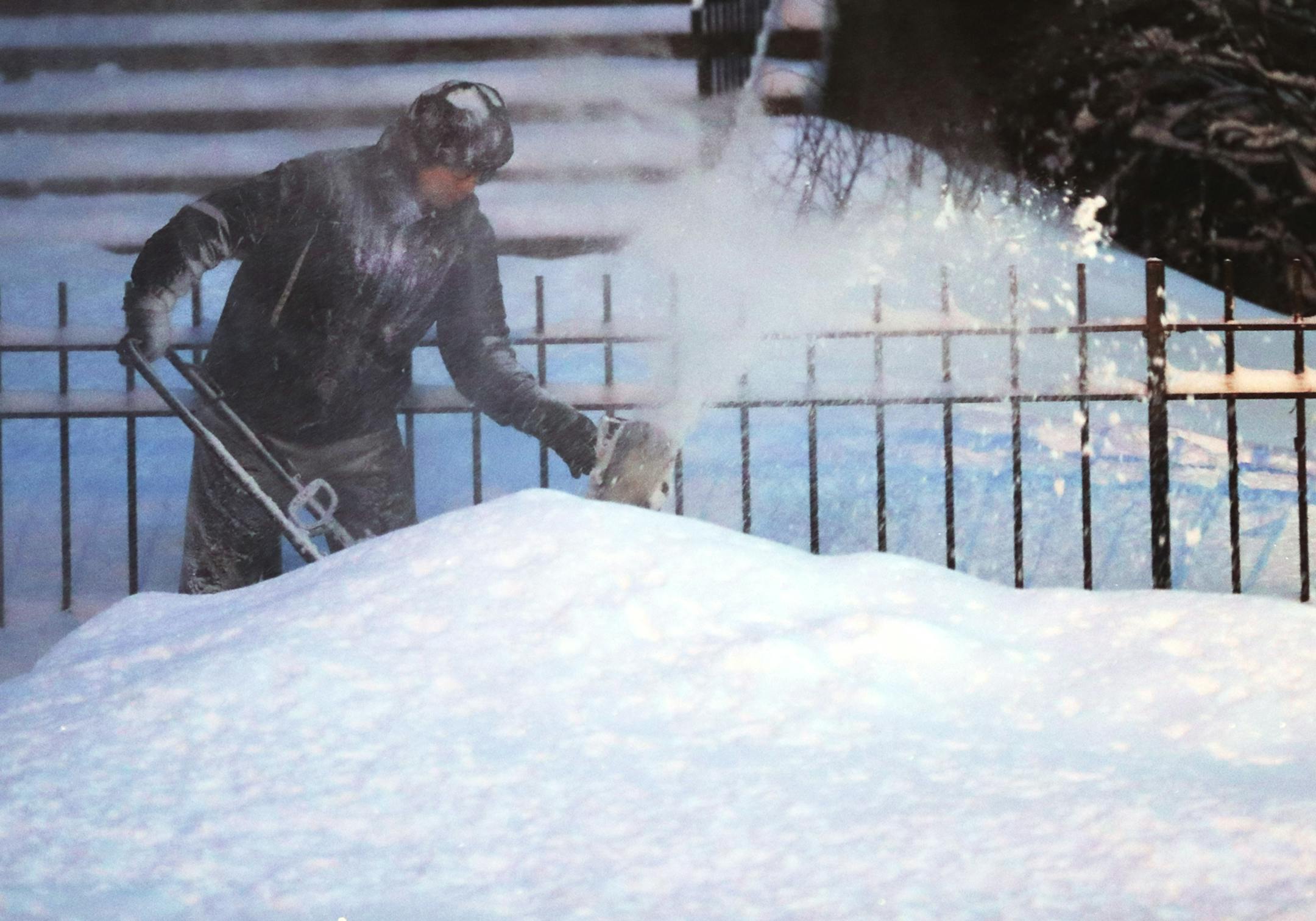 Maintenance person Phillip Garza blows snow in front of a group of apartments Tuesday, Feb. 12, 2019, in Minneapolis, MN. It was Garza's first time with a new snow thrower. He said hand shoveling this February had left him feeling like "dying."