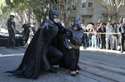 Miles Scott, dressed as Batkid, right, walks with Batman before saving a damsel in distress in San Francisco, Friday, Nov. 15, 2013. San Francisco tur