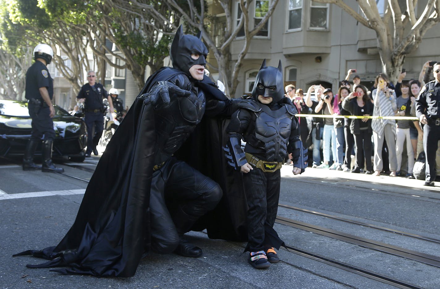 Miles Scott, dressed as Batkid, right, walks with Batman before saving a damsel in distress in San Francisco, Friday, Nov. 15, 2013. San Francisco turned into Gotham City on Friday, as city officials helped fulfill Scott's wish to be "Batkid."&#xac;&#x2020;Scott, a leukemia patient from Tulelake in far Northern California, was called into service on Friday morning by San Francisco Police Chief Greg Suhr to help fight crime, The Greater Bay Area Make-A-Wish Foundation says. (AP Photo/Jeff Chiu) O