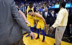 Golden State Warriors' Stephen Curry (30) limps back to the court after injuring his right ankle as teammate Draymond Green (23) checks on his conditi