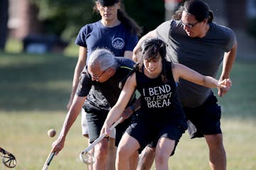 Sasha Houston Brown, center, battled for the ball during an evening of the Creator's game, which closely resembles lacrosse, in a Minneapolis park.